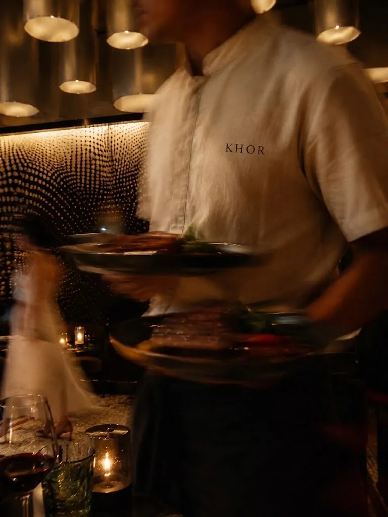 A KHOR server carrying plates through the dining room